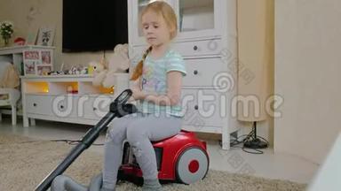 一个金发的小女孩坐在吸尘器上打扫卫生，带来秩序和清洁，帮助妈妈